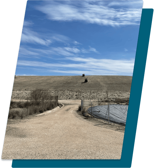 Camino rural en Aragersa con paisaje de colinas y cielo azul, zona natural de agricultura sostenible en Aragón.